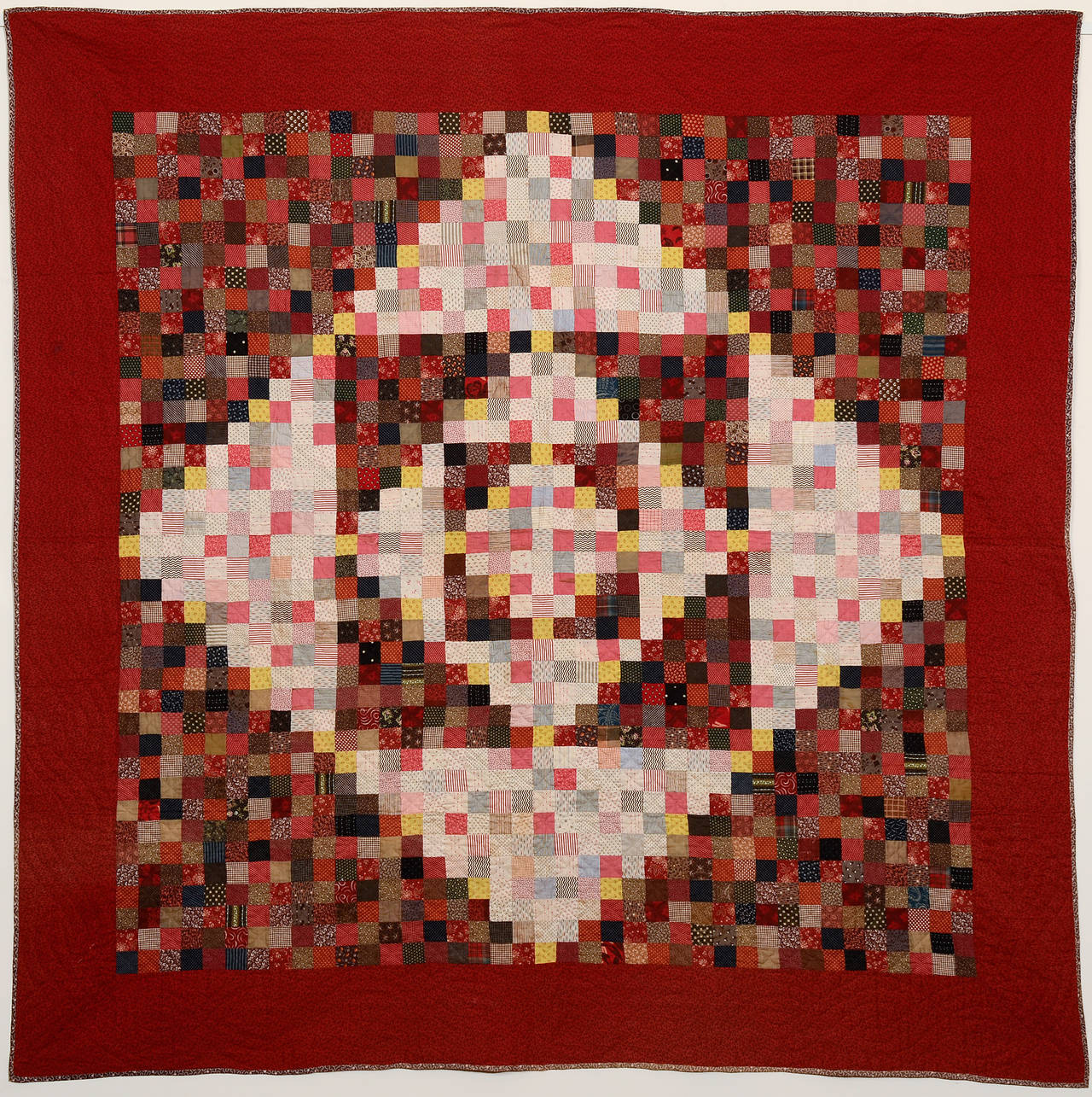 Rich red quilt with diamonds in square pattern. 