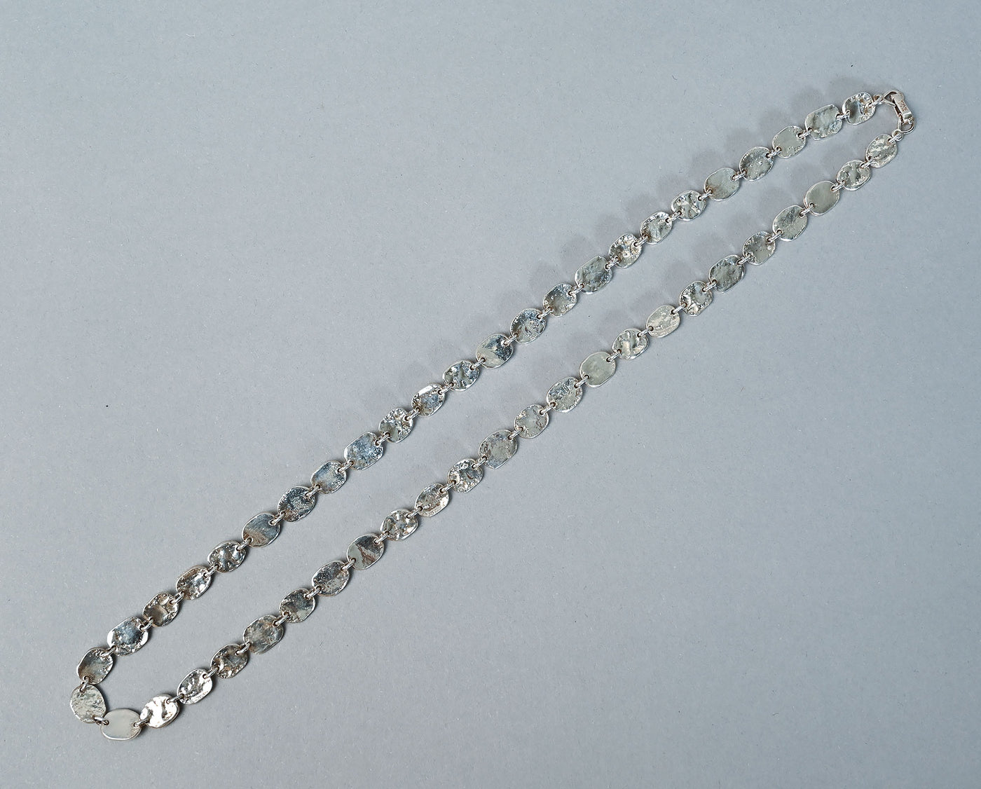 Backside top view of Tane Oval Silver Links Necklace with clasp closed.