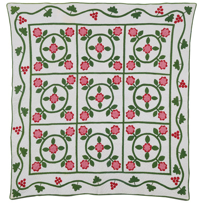 White antique quilt with pink flowers and green vines sold by Stella Rubin Antiques.