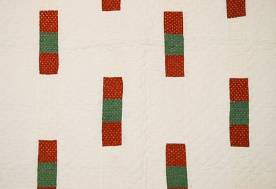 Close up of quilt fabric showing red and green patches with white polkadots.