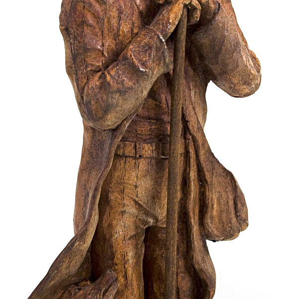 Wood Carving of a man holding a walking stick.