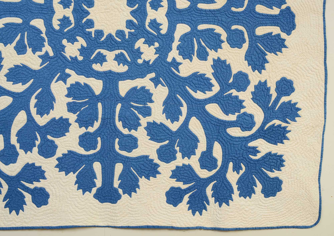 Bottom border of Hawaiian Applique Quilt Circa 1930's with blue flower on white background.