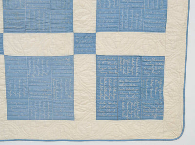 Bottom right corner of blue and white nine patch antique quilt with signatures.