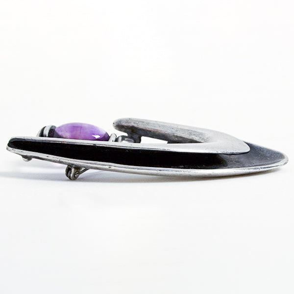 Side view of Sigi Pined boomerang brooch with amethyst. 