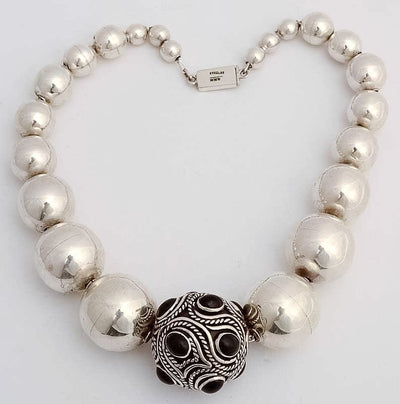 Large silver beads necklace with onyx and silver ball at the bottom.