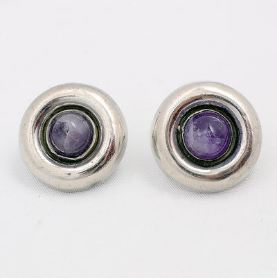 Round silver earrings with amethyst stones in the center.